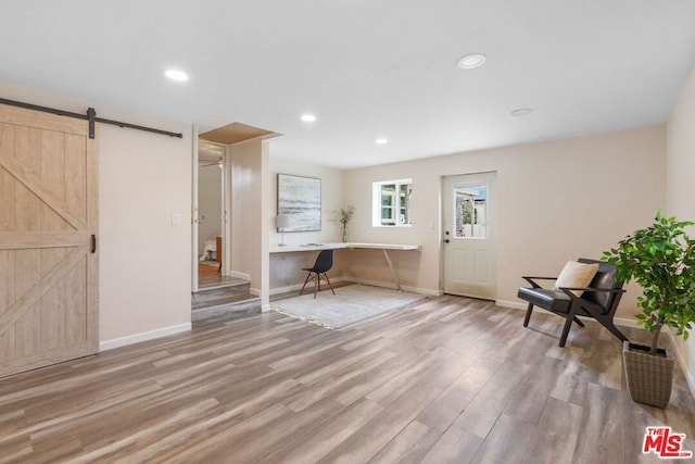 interior space with light hardwood / wood-style floors and a barn door