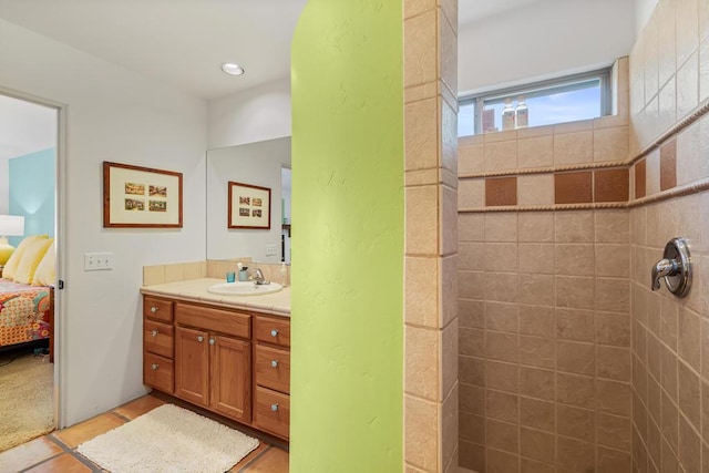 bathroom with tile patterned floors, vanity, and a tile shower