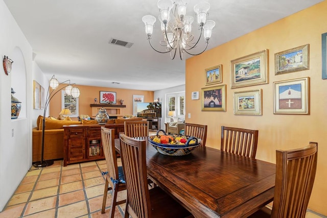 dining space featuring a notable chandelier and light tile patterned floors