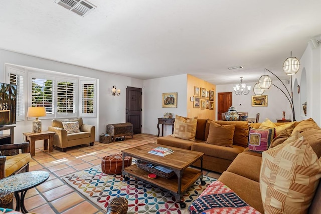 living room with light tile patterned floors and an inviting chandelier