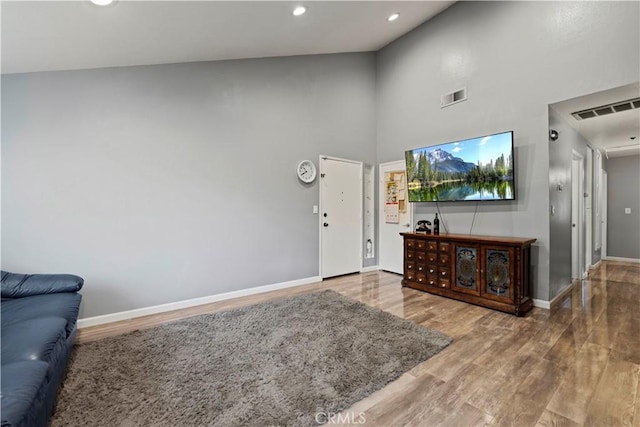 foyer entrance featuring high vaulted ceiling and wood-type flooring