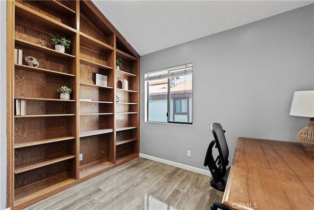 unfurnished office featuring light hardwood / wood-style flooring and vaulted ceiling