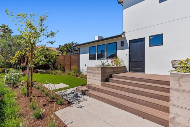 doorway to property featuring a lawn