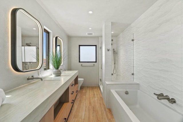 full bathroom with hardwood / wood-style floors, vanity, toilet, and separate shower and tub