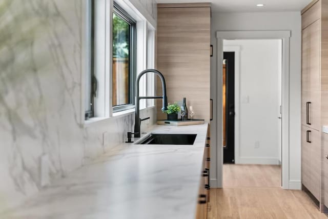 interior space with light stone counters and sink