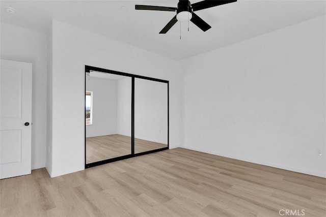 unfurnished bedroom with ceiling fan, light hardwood / wood-style floors, and a closet