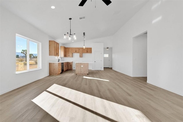 kitchen featuring a center island, ceiling fan with notable chandelier, sink, decorative light fixtures, and light hardwood / wood-style floors