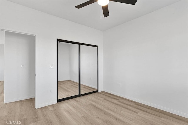 unfurnished bedroom featuring light wood-type flooring, a closet, and ceiling fan