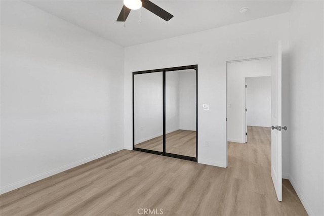 unfurnished bedroom with light wood-type flooring, a closet, and ceiling fan