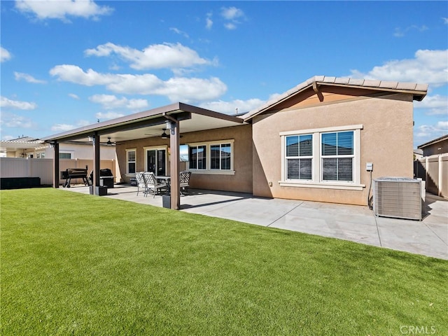 rear view of house with central AC, a patio area, ceiling fan, and a lawn