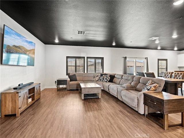 living room with hardwood / wood-style flooring and a textured ceiling