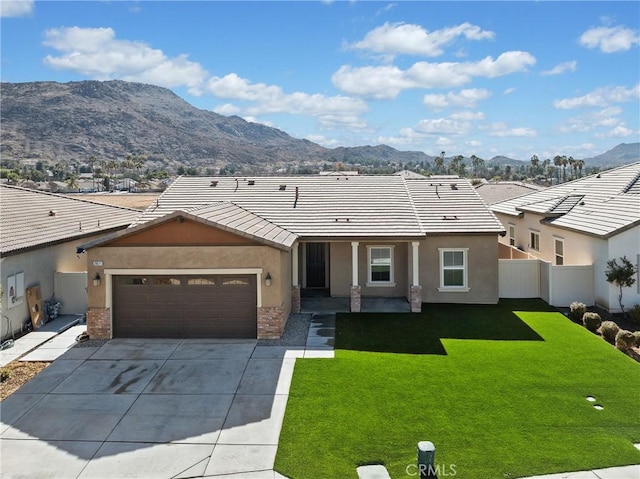 ranch-style house featuring a mountain view, a garage, and a front lawn