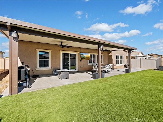 back of property with a patio, a yard, and ceiling fan