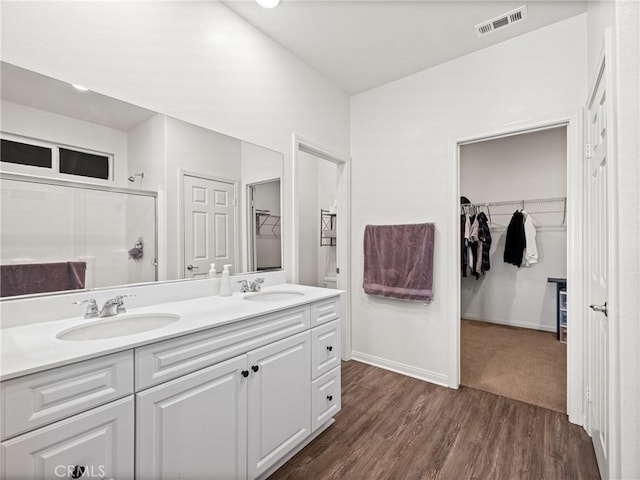 bathroom featuring vanity, wood-type flooring, and a shower with shower door