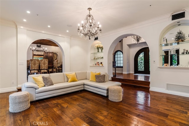 living room featuring dark hardwood / wood-style floors, ornamental molding, and an inviting chandelier