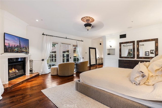 bedroom with access to outside, a high end fireplace, ceiling fan, ornamental molding, and dark hardwood / wood-style flooring