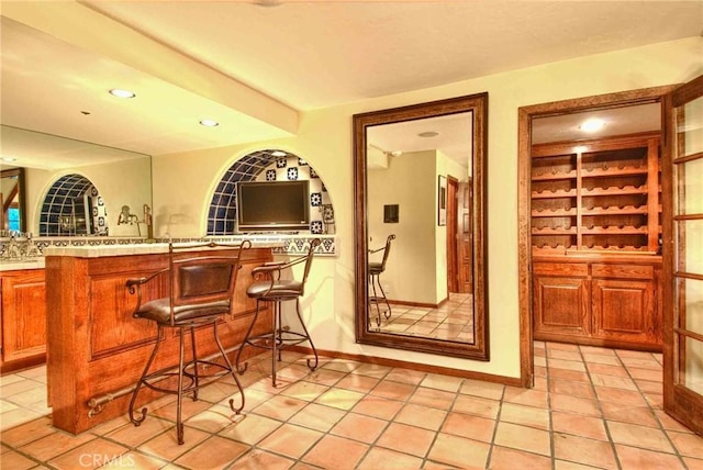 bar with built in features and light tile patterned floors