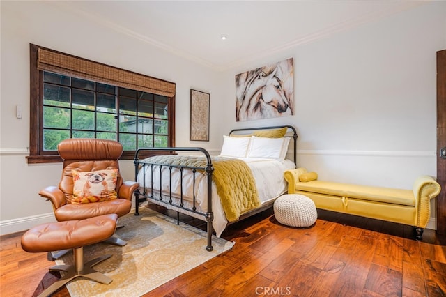 bedroom featuring crown molding and wood-type flooring