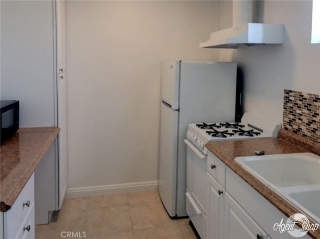 kitchen with tasteful backsplash, sink, light tile patterned floors, white range with gas stovetop, and white cabinetry