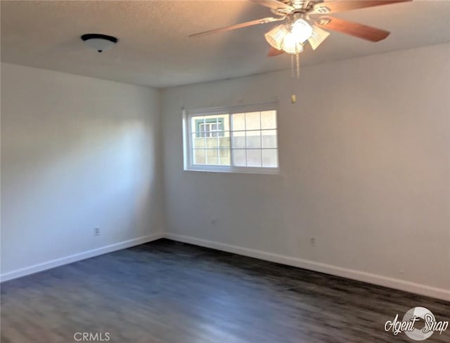 spare room featuring ceiling fan and dark wood-type flooring