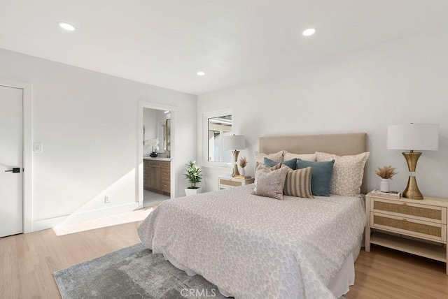 bedroom with ensuite bath and wood-type flooring