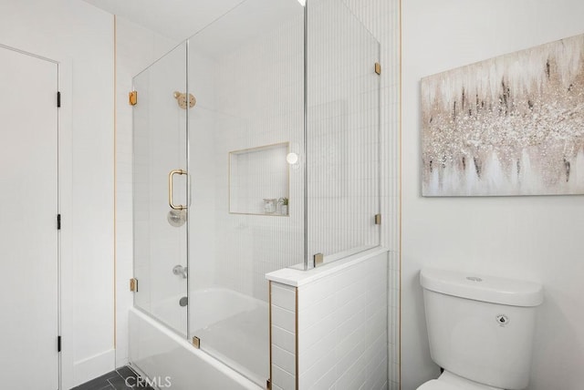 bathroom featuring shower / bath combination with glass door and toilet