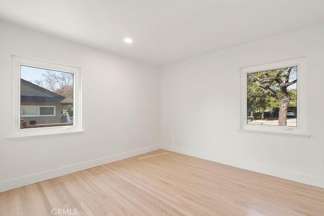 unfurnished room featuring plenty of natural light and light hardwood / wood-style floors