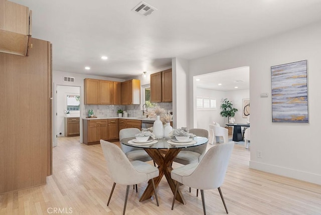 dining room with light hardwood / wood-style floors and sink