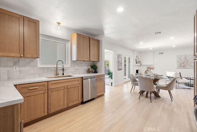 kitchen featuring decorative backsplash, dishwasher, light hardwood / wood-style flooring, and sink