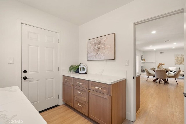 kitchen with light stone countertops and light wood-type flooring