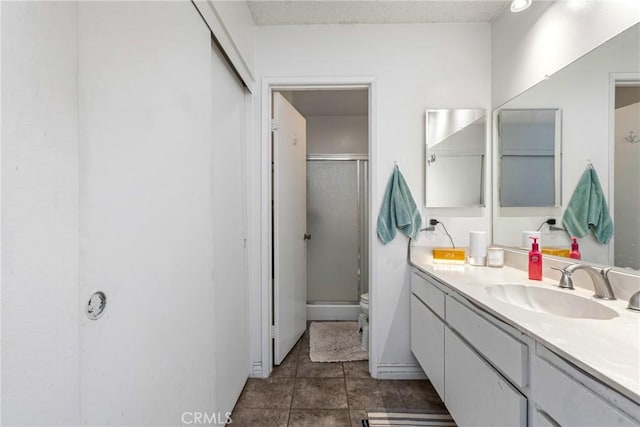 bathroom featuring vanity, toilet, and a shower with shower door