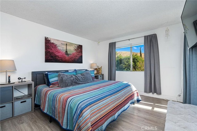 bedroom with hardwood / wood-style floors and a textured ceiling