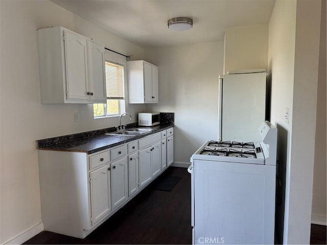 kitchen featuring dark hardwood / wood-style flooring, white cabinetry, sink, and white appliances