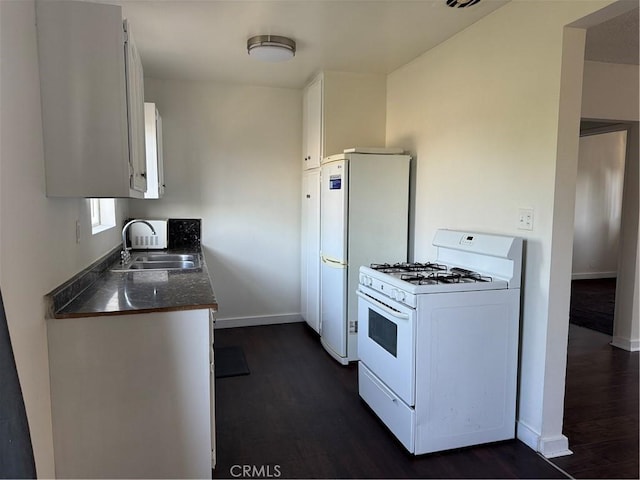 kitchen featuring dark hardwood / wood-style flooring, sink, white cabinets, and white appliances