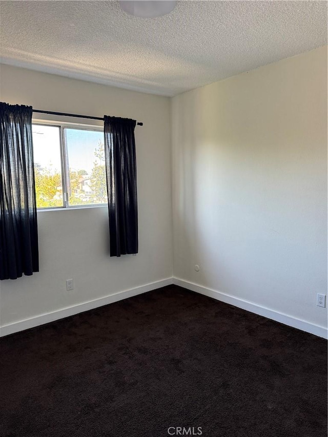 carpeted empty room with a textured ceiling