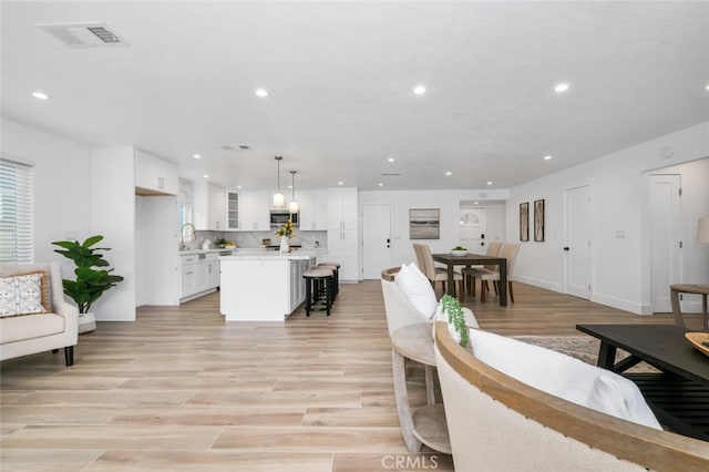 living room with sink and light wood-type flooring