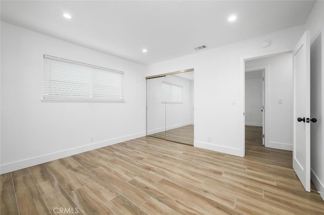 unfurnished bedroom featuring light wood-type flooring and a closet