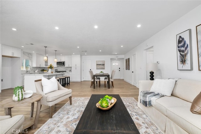 living room featuring sink and light hardwood / wood-style floors