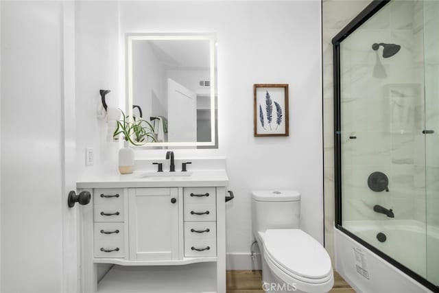 full bathroom featuring shower / bath combination with glass door, vanity, and toilet