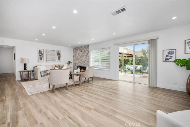 living room with light wood-type flooring and a fireplace