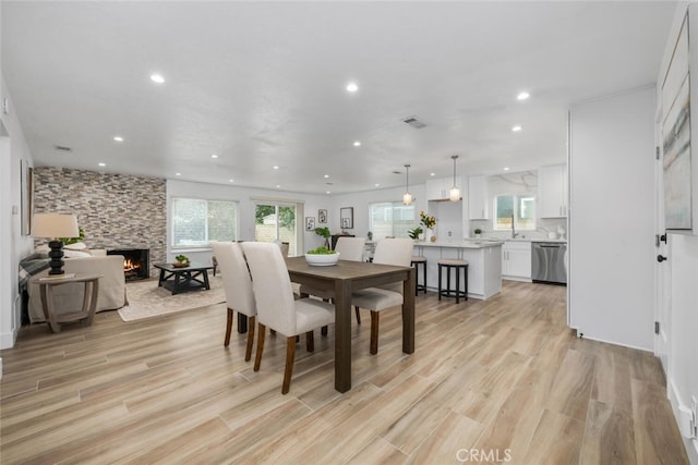 dining space with a fireplace and light hardwood / wood-style floors