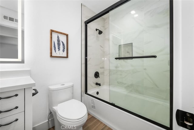 full bathroom with hardwood / wood-style flooring, vanity, toilet, and enclosed tub / shower combo