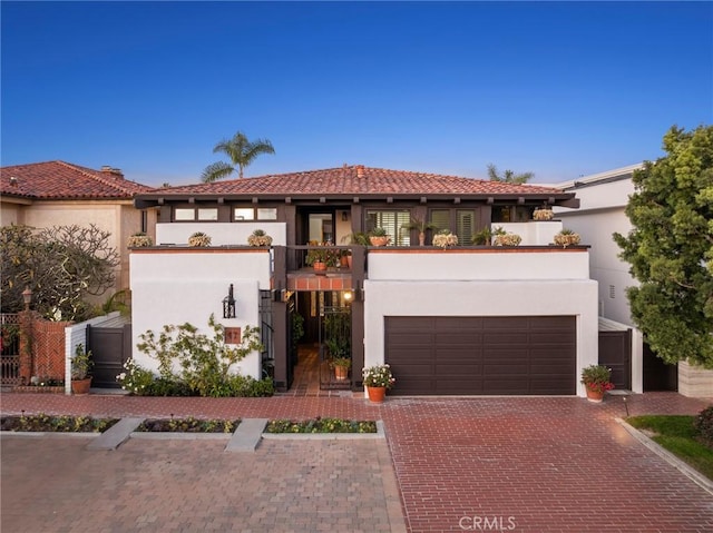 mediterranean / spanish house featuring a garage and a balcony