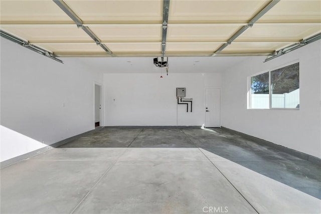 garage with a garage door opener, electric panel, and baseboards