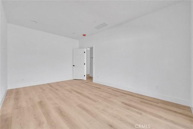 unfurnished room with light wood-style flooring, visible vents, and baseboards