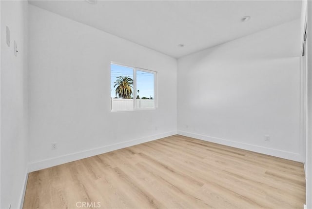 unfurnished room with baseboards and wood finished floors