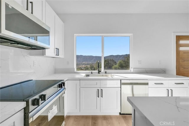 kitchen with white cabinets, a mountain view, sink, and appliances with stainless steel finishes