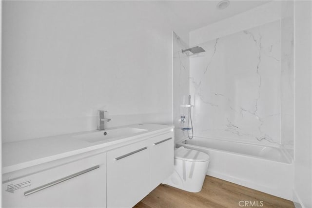 full bathroom featuring vanity, toilet, wood-type flooring, and tiled shower / bath