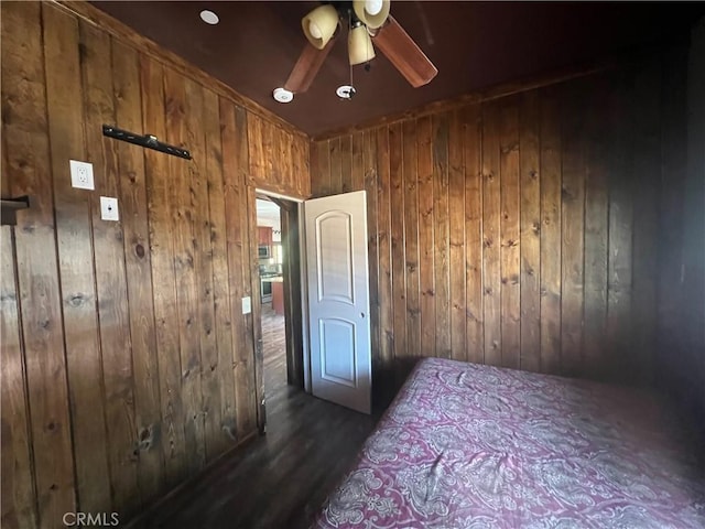 unfurnished bedroom featuring ceiling fan and wood walls