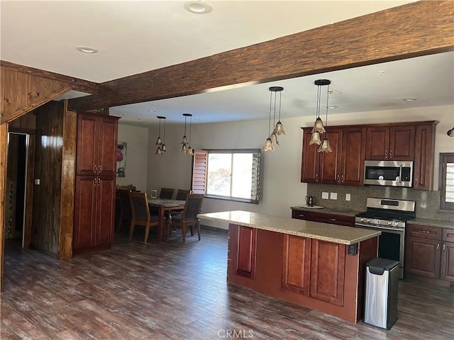 kitchen with a center island, tasteful backsplash, dark hardwood / wood-style flooring, decorative light fixtures, and appliances with stainless steel finishes